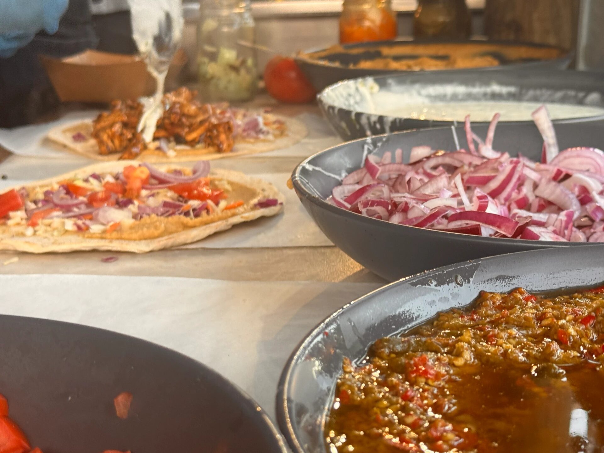 Hestia market stall counter with fresh pitas, red onion and homemade relish